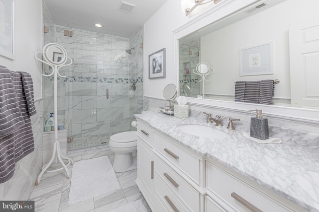 bathroom featuring a shower with door, vanity, and toilet