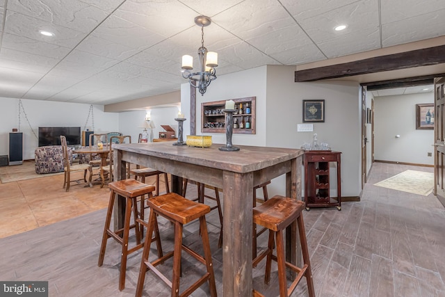 bar with hardwood / wood-style floors and a chandelier