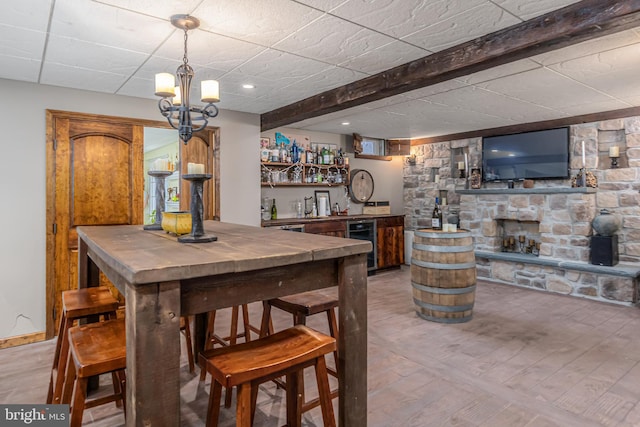 bar with beverage cooler and a stone fireplace