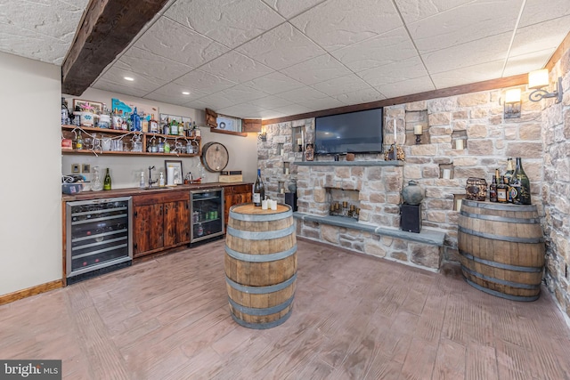 bar with sink, beverage cooler, hardwood / wood-style floors, and beamed ceiling