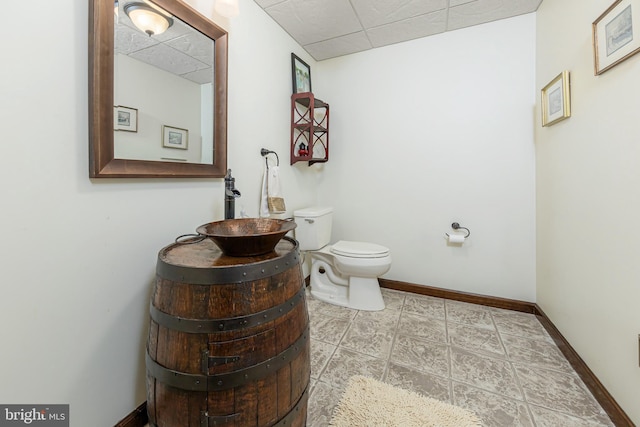 bathroom with toilet and a paneled ceiling