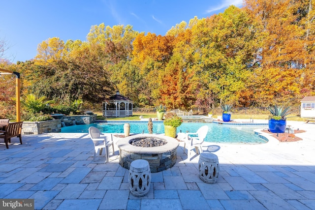 view of pool featuring a gazebo, a fire pit, an in ground hot tub, and a patio area