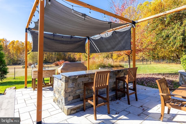 view of patio with exterior bar and area for grilling