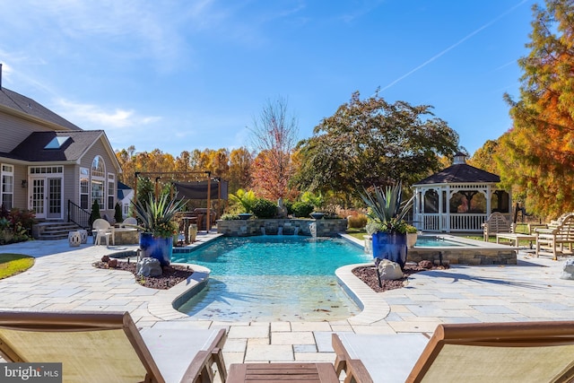 view of swimming pool with french doors, pool water feature, a patio area, and a gazebo