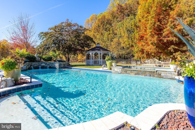 view of pool featuring a gazebo, pool water feature, and an in ground hot tub