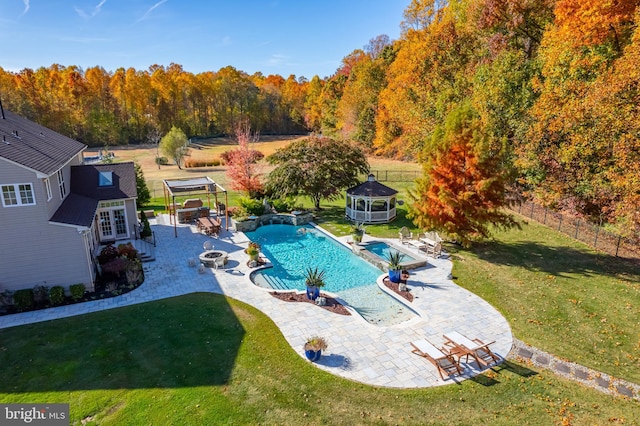 view of swimming pool with a yard, a gazebo, an outdoor structure, a fire pit, and a patio area