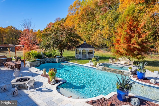 view of pool with a fire pit, an in ground hot tub, a patio, and a gazebo