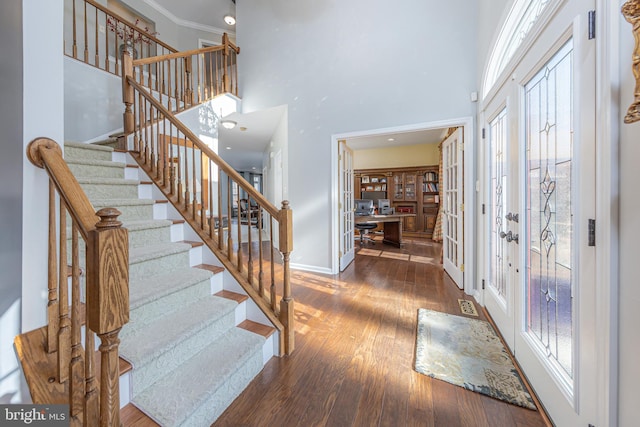 foyer featuring french doors, ornamental molding, a wealth of natural light, and dark wood-type flooring