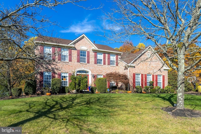 colonial-style house featuring a front yard