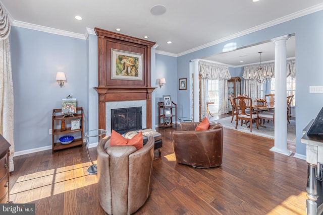 living room featuring a premium fireplace, a chandelier, decorative columns, and dark wood-type flooring