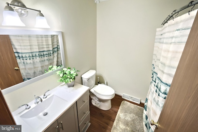 bathroom featuring vanity, toilet, and hardwood / wood-style floors