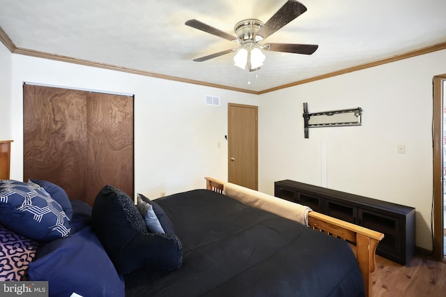 bedroom with crown molding, wood-type flooring, and ceiling fan