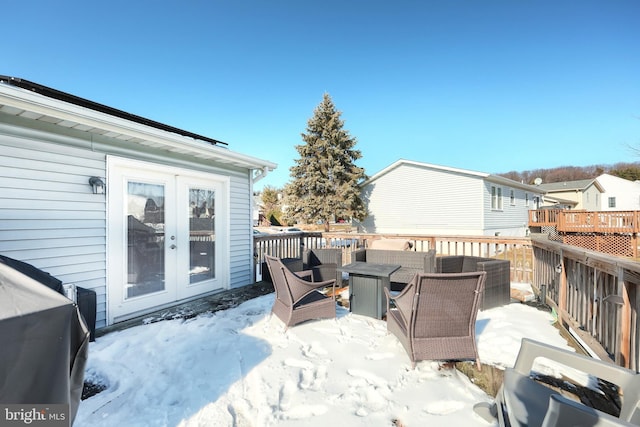 snow covered patio featuring a deck