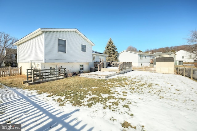 snow covered rear of property with a deck