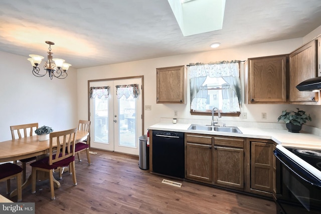 kitchen featuring dishwasher, sink, hanging light fixtures, and a wealth of natural light