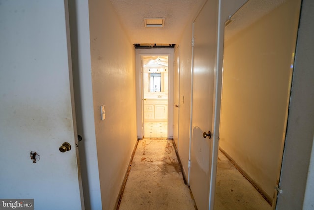 corridor featuring a textured ceiling