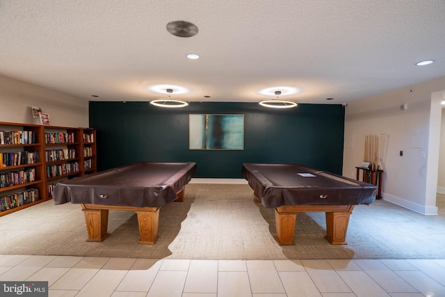 playroom featuring light carpet, pool table, and a textured ceiling