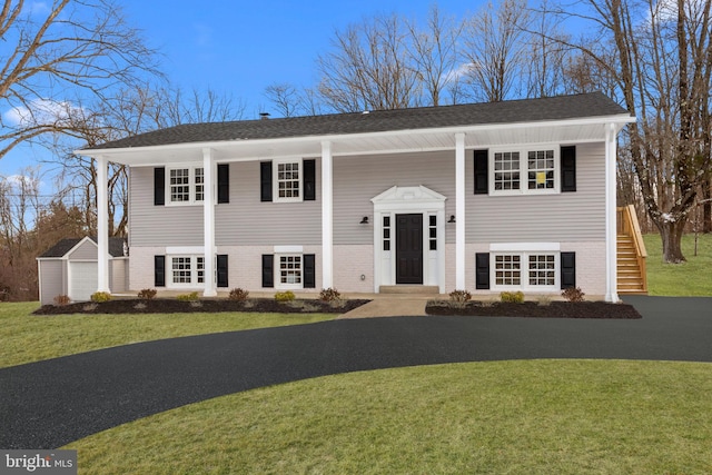 split foyer home featuring an outbuilding and a front yard