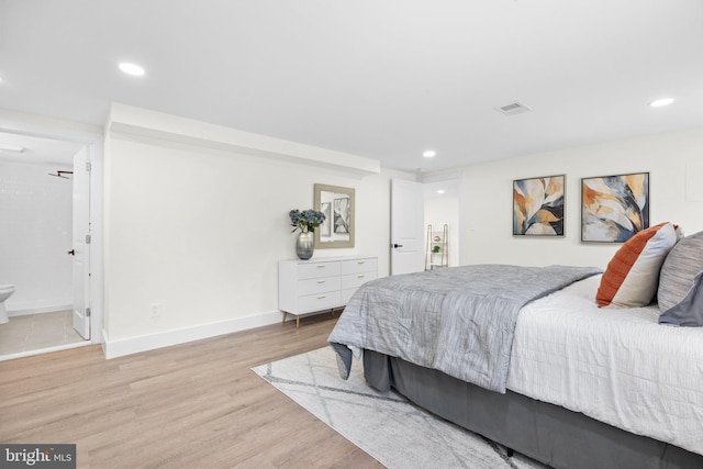 bedroom featuring ensuite bathroom and light hardwood / wood-style floors