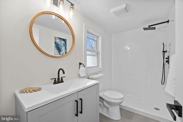 bathroom featuring tile patterned floors, vanity, toilet, and tiled shower