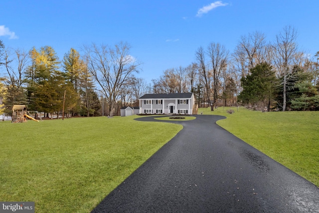 split foyer home with a shed, a playground, and a front yard