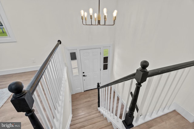 stairway featuring hardwood / wood-style flooring and an inviting chandelier