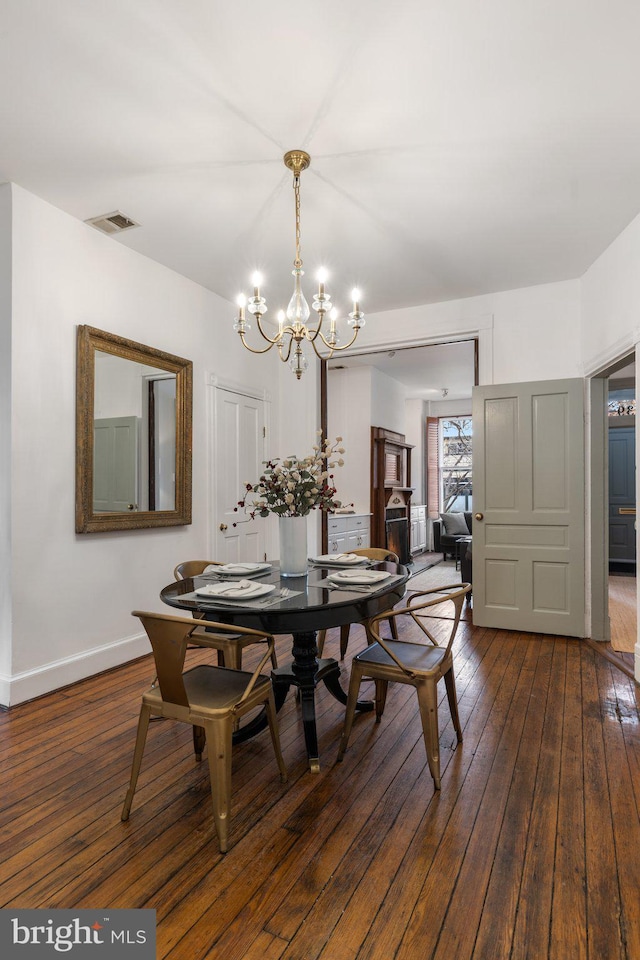 dining area featuring dark hardwood / wood-style floors and a notable chandelier