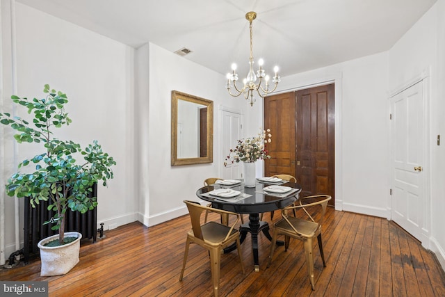 dining area featuring dark wood-type flooring and a chandelier