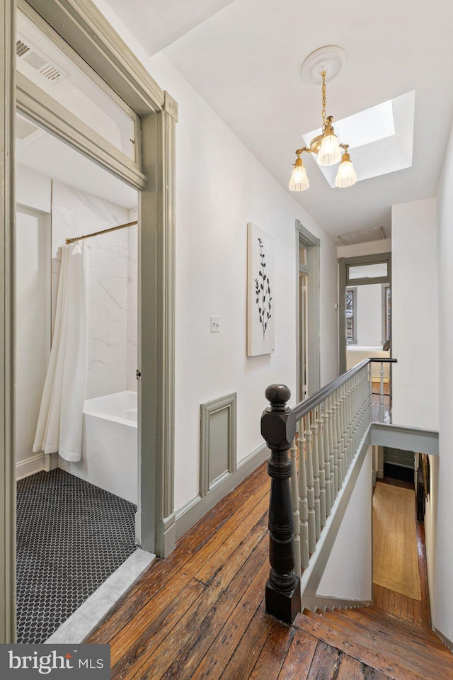 hall featuring dark hardwood / wood-style floors and a skylight