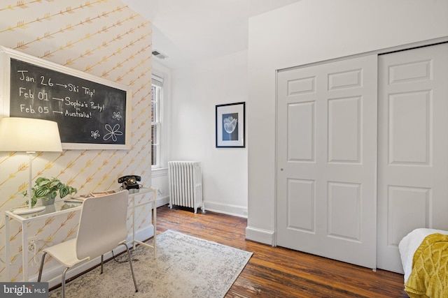 office area with radiator heating unit and dark wood-type flooring