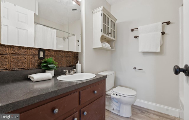 bathroom featuring toilet, vanity, backsplash, and hardwood / wood-style floors