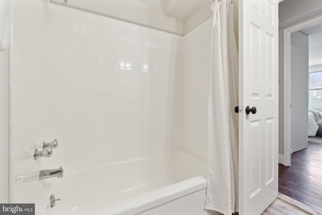 bathroom featuring shower / bathtub combination with curtain and hardwood / wood-style floors