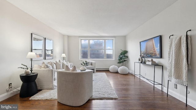 living room with a baseboard heating unit and dark hardwood / wood-style floors