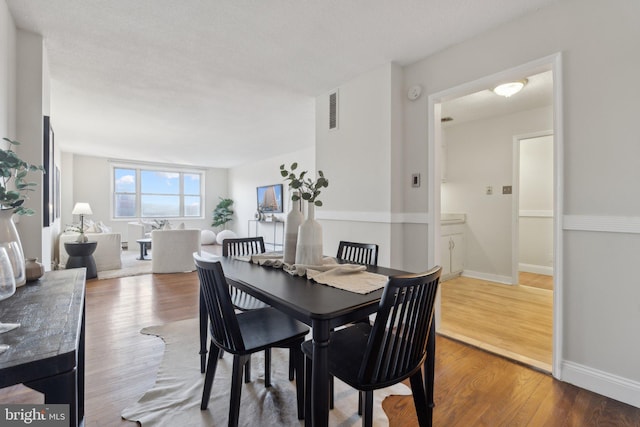 dining space with wood-type flooring