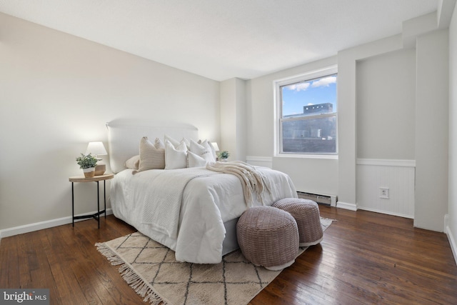 bedroom with a baseboard radiator and dark hardwood / wood-style floors