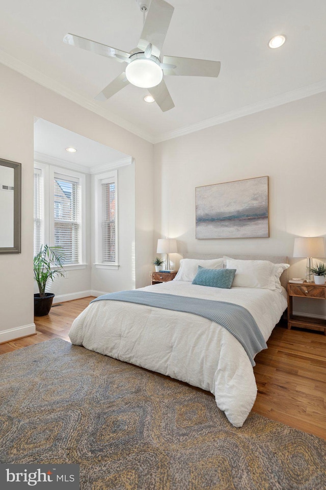 bedroom featuring crown molding, hardwood / wood-style floors, and ceiling fan