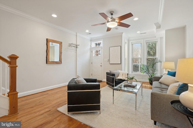 living room featuring crown molding, ceiling fan, and light wood-type flooring