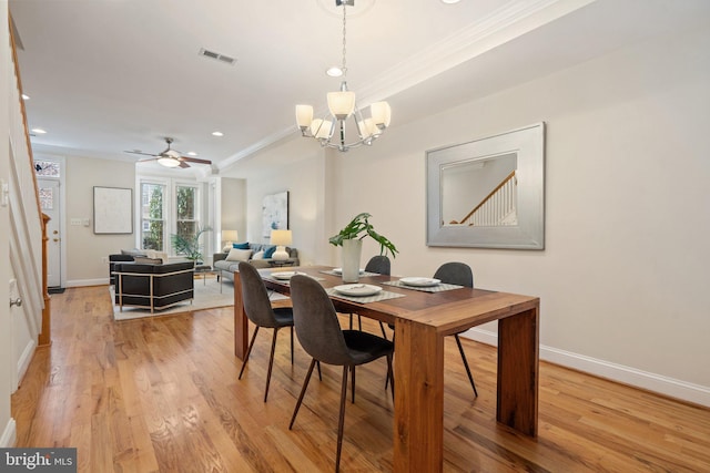 dining space with hardwood / wood-style floors, crown molding, and ceiling fan with notable chandelier