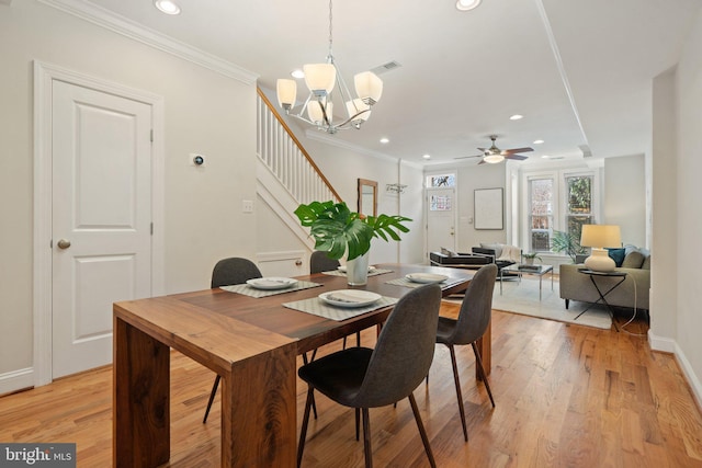 dining space with ceiling fan with notable chandelier, light hardwood / wood-style flooring, and ornamental molding