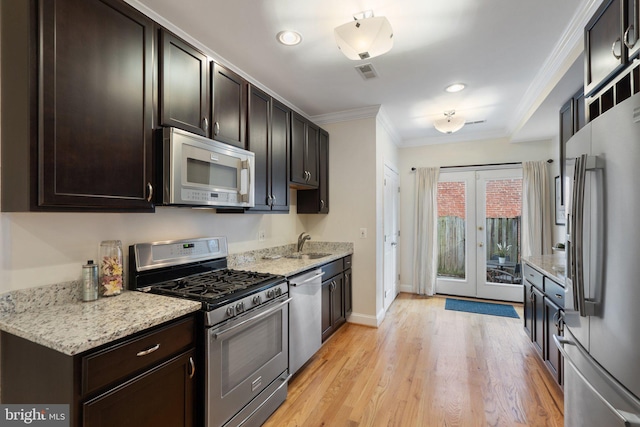 kitchen featuring sink, ornamental molding, light stone counters, stainless steel appliances, and light hardwood / wood-style flooring