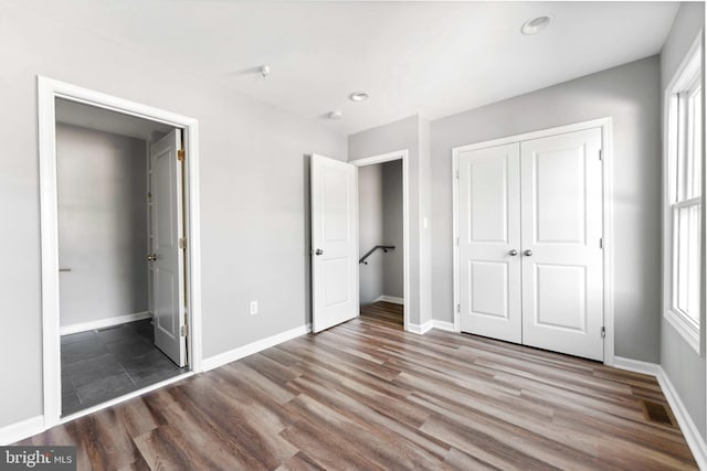 unfurnished bedroom featuring hardwood / wood-style floors and a closet