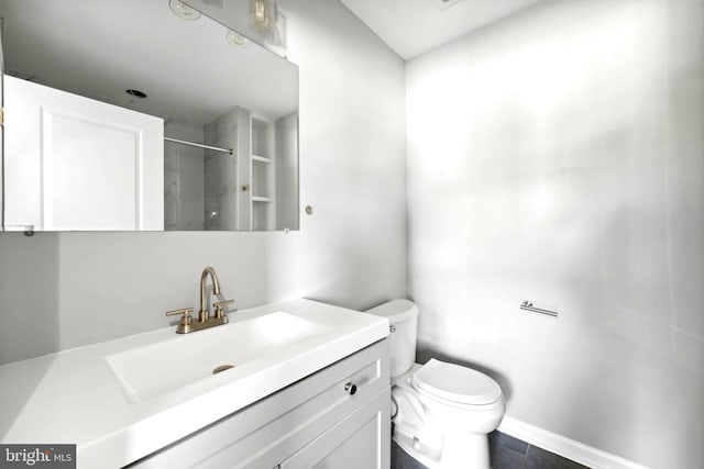 bathroom with tile patterned floors, vanity, toilet, and walk in shower