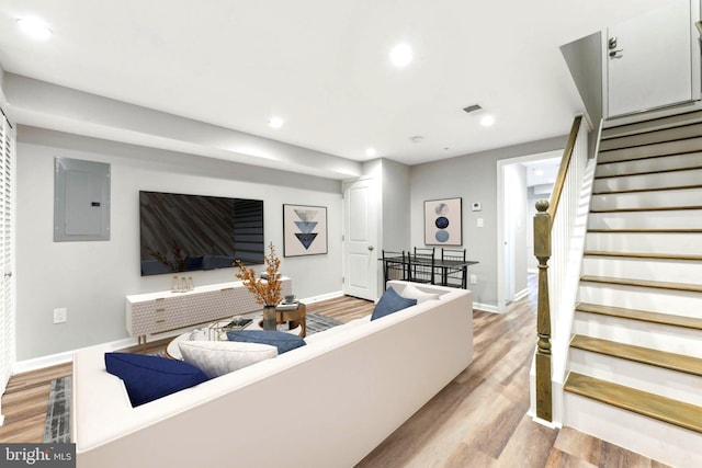 living room featuring electric panel and light hardwood / wood-style floors