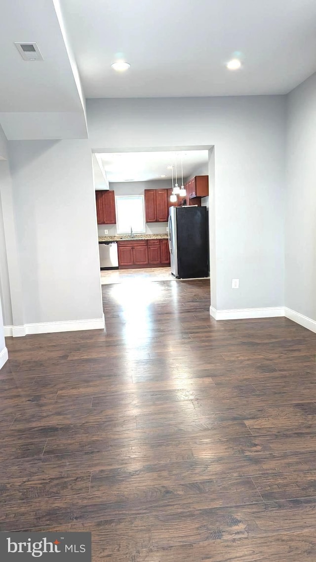 unfurnished living room with dark wood-type flooring and sink