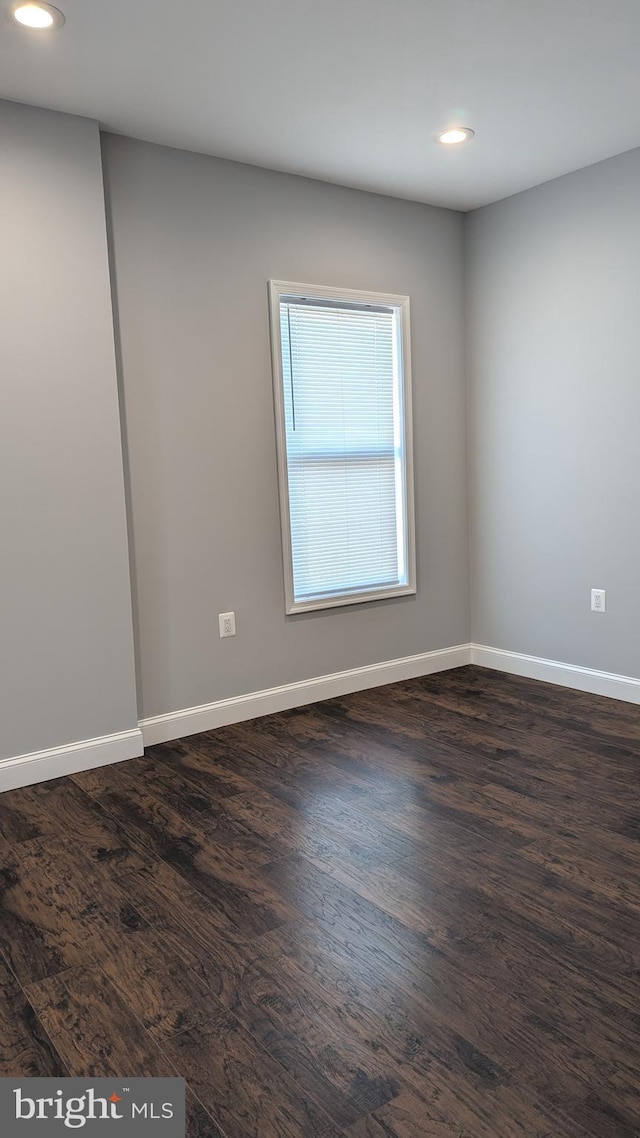 spare room with dark hardwood / wood-style flooring