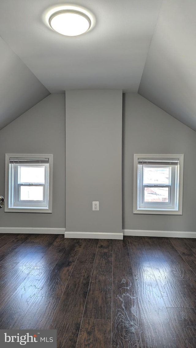 bonus room with dark wood-type flooring, a wealth of natural light, and vaulted ceiling