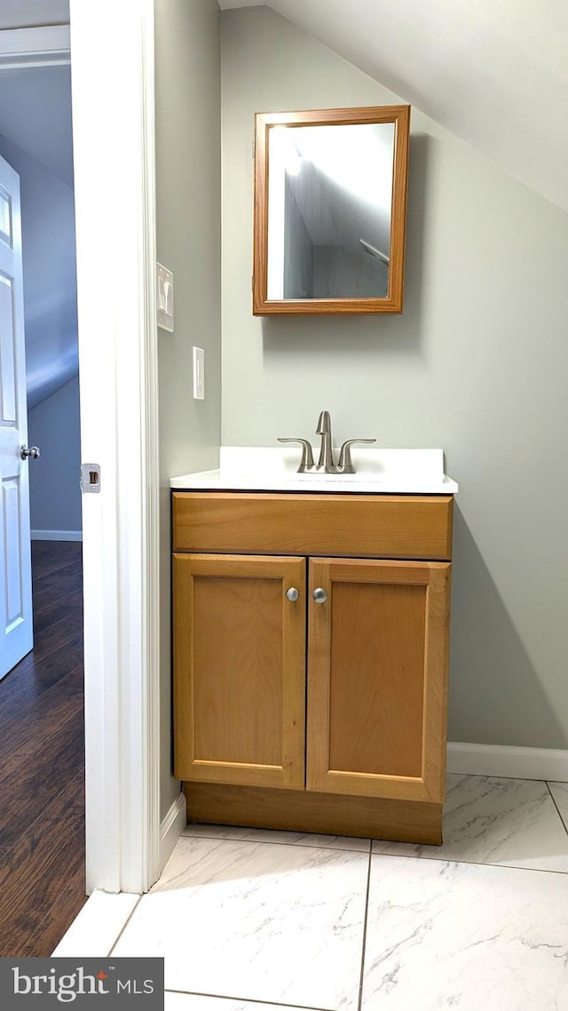 bathroom with lofted ceiling and vanity