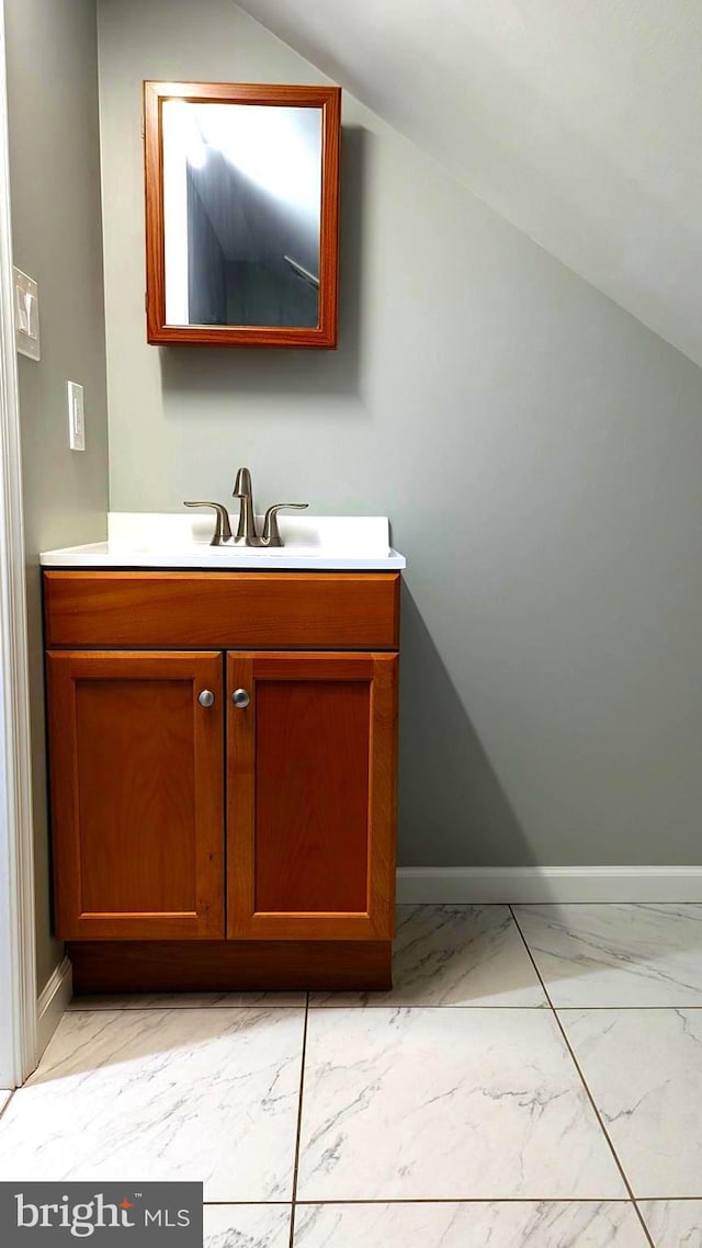 bathroom with vanity and lofted ceiling