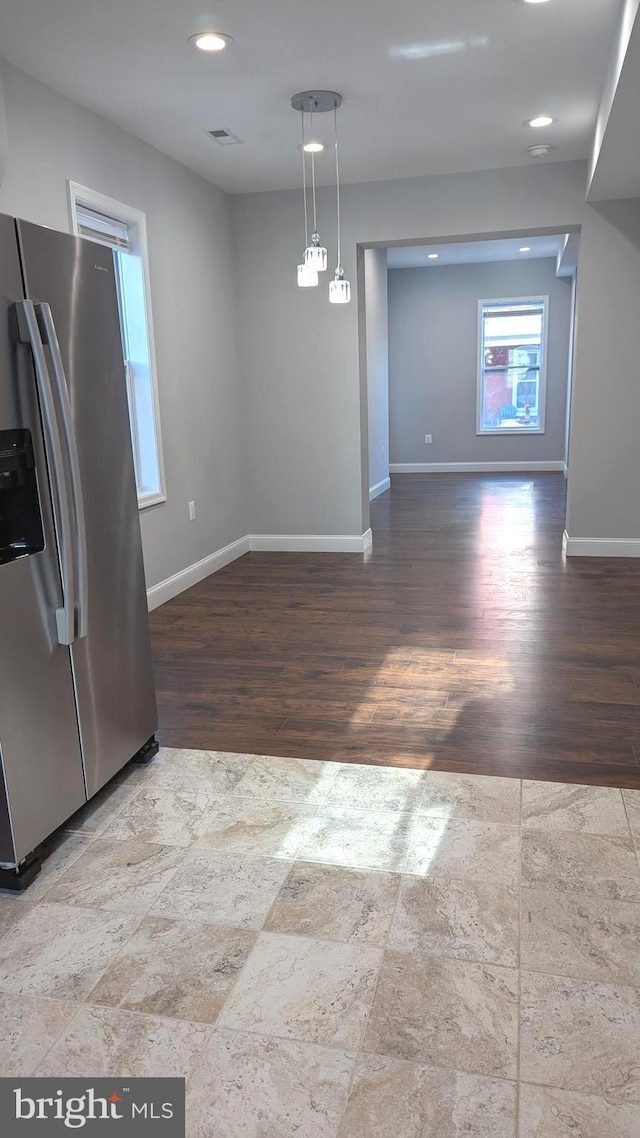 kitchen featuring stainless steel refrigerator with ice dispenser, hardwood / wood-style flooring, and pendant lighting