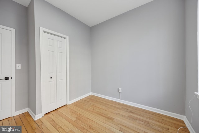 unfurnished bedroom featuring a closet and hardwood / wood-style floors